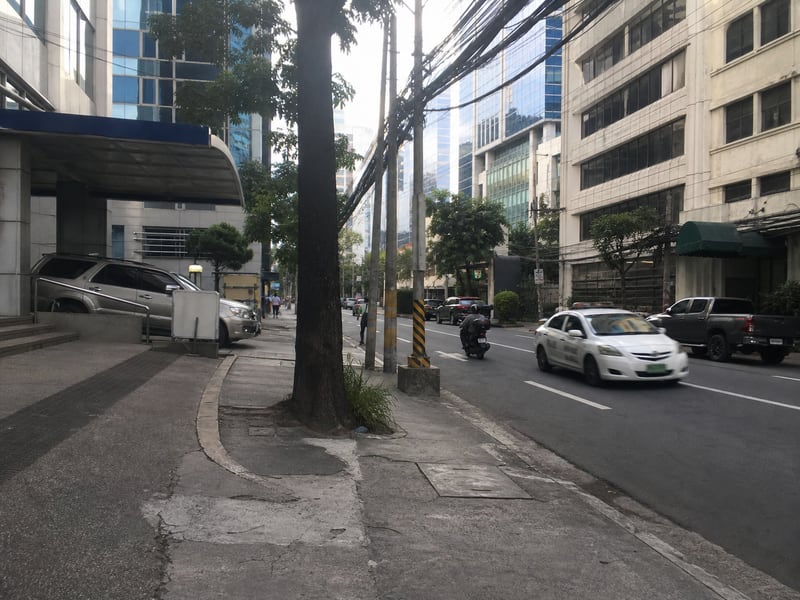 马尼拉写字楼街区清晨随手拍：普通人行道、车流与热带树影